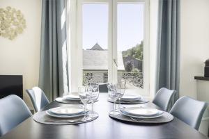 una mesa de comedor con vasos y sillas y una ventana en Villa Pax 3 - La Bourboule - 6pers, en La Bourboule