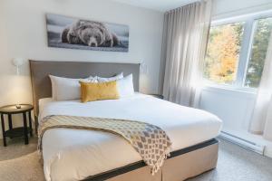 a bedroom with a bed and a large window at Suites du Lac Moore in Mont-Tremblant