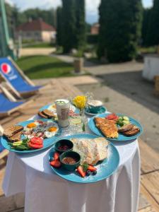 a table with three plates of food on it at Raketa Residence, hotel & restaurant in Brezany