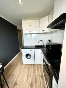 a kitchen with a washer and dryer in a room at Panorama Apartment Kraków in Krakow