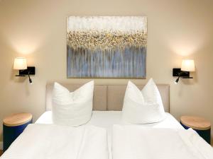a bedroom with two white beds and two lamps at Appartements "Zum Leuchtturm" Hafen Rankwitz Insel Usedom in Rankwitz
