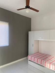 um quarto com uma cama e uma ventoinha de tecto em Apartamento mobiliado em Maricá próximo ao centro em Maricá