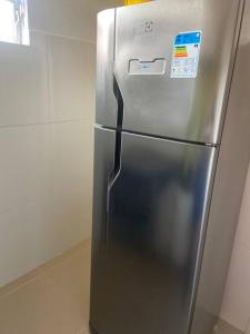 um frigorífico de aço inoxidável sentado numa cozinha em Apartamento mobiliado em Maricá próximo ao centro em Maricá