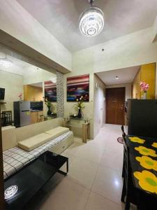 a living room with a couch and a kitchen at SHELL RESIDENCE in Manila