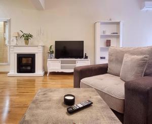 a living room with a couch and a television at Antik Apartman in Stara Pazova