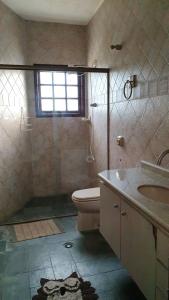 La salle de bains est pourvue de toilettes et d'un lavabo. dans l'établissement Chácara guararema, à Guararema