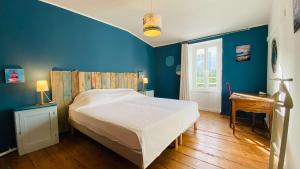 Un dormitorio con una cama y una pared azul. en Charme et authenticité pour cette villa rhétaise, en Sainte-Marie-de-Ré