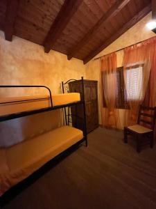 a room with two bunk beds and a chair at La Casa sulla collina "Baccu e Idda" in Chia