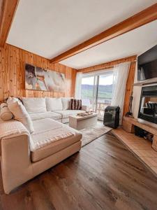 un soggiorno con divano e camino di Magnifique VUE LAC et SKI a Mont-Tremblant