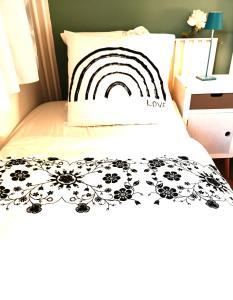 a bed with a black and white comforter with a rainbow on it at Super appartment at Paris in Paris