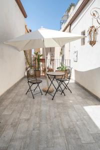 a table and chairs with an umbrella on a patio at Ziolì in Noto