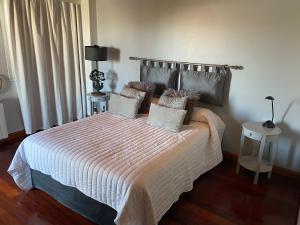 1 dormitorio con 1 cama con edredón blanco en Palacios 1190 en Las Heras