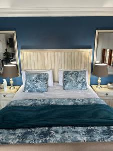 a bedroom with a large bed with blue walls and two lamps at Mt Horeb Manor in Clarens