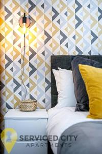 a bedroom with a bed and a geometric wall at SCA - Delightful Studio - VS3 in Wolverhampton