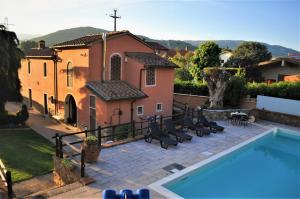 a villa with a swimming pool in front of a house at La Bella Toscana Ulivo Apartment in Monsummano Terme