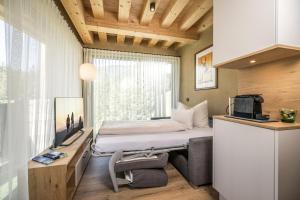 a small bedroom with a bed and a window at Natur Zeit - Alpine Garden Apartments in Mayrhofen
