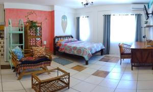 Cool Vibes Beach Hostel في دومينيكال: غرفة نوم بها سرير وكرسي وطاولة