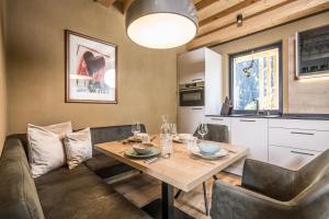 cocina y comedor con mesa y sillas en Natur Zeit - Alpine Garden Apartments en Mayrhofen