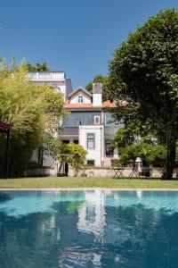 a swimming pool in front of a building at Marquês Garden House by Olivia in Porto