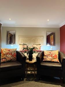 uma sala de estar com duas cadeiras e uma cama em Mt Horeb Manor em Clarens