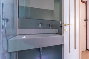 un lavandino bianco in un bagno con uno specchio di A due passi da Camogli Near to Camogli, apartment with terrace and seaside view a Recco Altre 12 foto