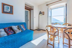 un soggiorno con un divano blu e un tavolo di A due passi da Camogli Near to Camogli, apartment with terrace and seaside view a Recco