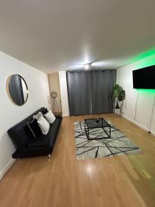 a living room with a black couch and a table at Cozy 1 bedroom apartments in East London in London