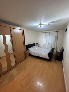 a bedroom with a bed and a wooden floor at Cozy 1 bedroom apartments in East London in London