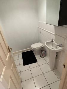 a white bathroom with a toilet and a sink at Cozy 1 bedroom apartments in East London in London