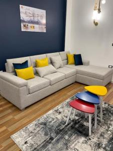 a living room with a couch with yellow and blue pillows at luxury apartment at Obour, 5th floor no elevator in Cairo