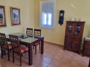 uma sala de jantar com mesa e cadeiras e um relógio em Casa Hidalgo em Baena