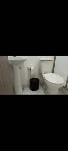 a bathroom with a white toilet and a sink at Charming Village, Tiny House in Santa Marta