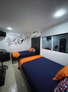 una camera con due letti e uno specchio di Casa Turística Realismo Mágico a Aracataca