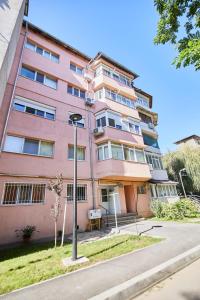 un edificio rosa con una luz de la calle delante de él en ChECk apartment, en Focşani