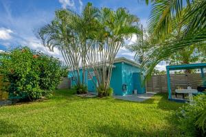 a blue house with a palm tree in the yard at Cozy 11 & Patio Near The Beach- Unit #3 in Hollywood