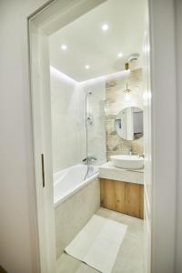 a bathroom with a tub and a sink at ChECk apartment in Focşani +18 photos