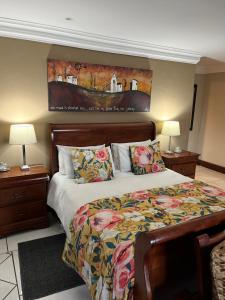 a bedroom with a bed and a painting on the wall at Mt Horeb Manor in Clarens