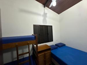 a bedroom with two bunk beds and a window at TRIPLEX piscina churrasqueira lava e seca Wi-Fi e 2 TVs em Condomínio com 90m2 no centro de Ubatuba in Ubatuba