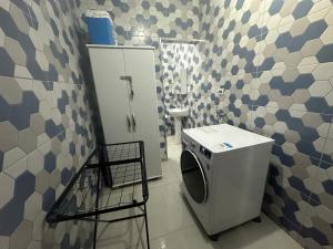 a bathroom with a washer and dryer in it at TRIPLEX piscina churrasqueira lava e seca Wi-Fi e 2 TVs em Condomínio com 90m2 no centro de Ubatuba in Ubatuba