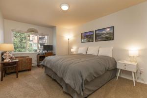 Un dormitorio con una cama y un escritorio y una ventana. en Fifth Avenue Retreat: Dog Friendly Frisco Townhome, en Frisco