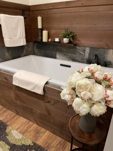 a bath tub with a vase of flowers in a bathroom at The Dogwood Inn in Blue Ridge