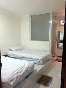 Duas camas num quarto com uma janela em Bonsai Homestay Kluang - B17 em Keluang