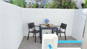 une table et des chaises sur une terrasse agrémentée de plantes dans l'établissement Victoria Apartment - Center of Ponta Delgada, à Ponta Delgada