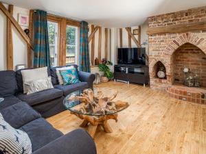 uma sala de estar com um sofá e uma lareira em Pass the Keys Bradenham Barn in The Chiltern Hills em Bradenham