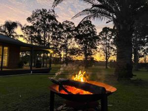 a fire pit in a park with the sunset in the background at Bella Farm Country House Hunter Valley in Nulkaba