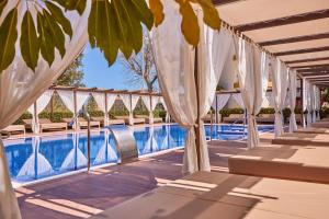 una piscina de hotel con sombrillas blancas en Zafiro Tropic, en Puerto de Alcudia