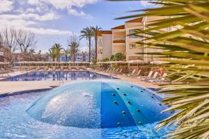 una piscina con un tobogán de agua azul frente a un edificio en Zafiro Tropic, en Puerto de Alcudia