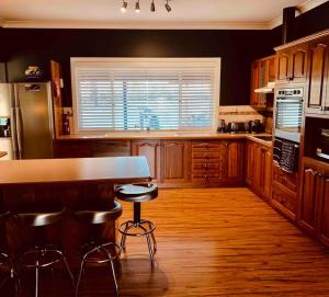 a kitchen with a counter and stools in it at Bella Farm Country House Hunter Valley in Nulkaba