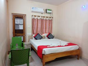 a bedroom with a bed and a table and a chair at Bay Inn in Puri
