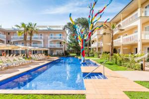 a resort pool with chairs and a resort at Zafiro Can Picafort in Can Picafort